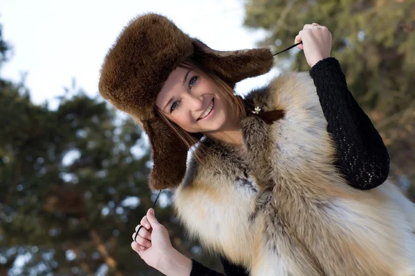 Chica joven en un chaleco de piel en los bosques nevados — Foto de Stock