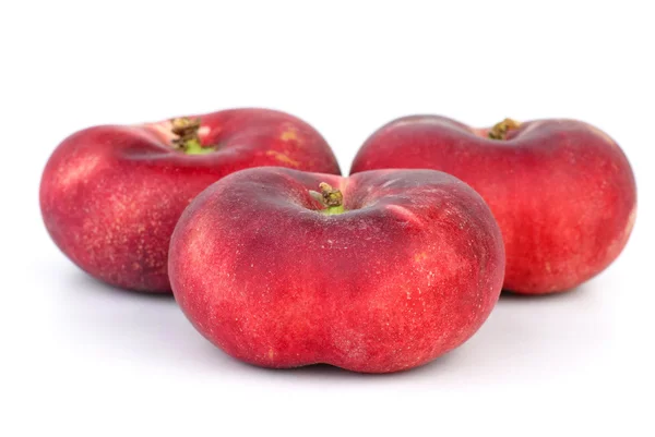 Три червоні плоскі персики — стокове фото