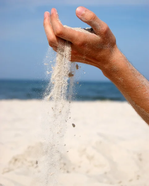 Sand som faller från mannens hand — Stockfoto