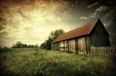 Sunset by an old barn clipart