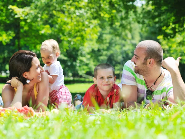 Щаслива молода пара зі своїми дітьми розважається в парку — стокове фото