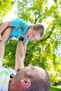 Happy father and son have fun at park clipart