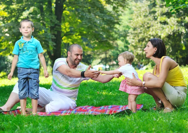 Cuplu tânăr fericit cu copiii lor se distrează în parc — Fotografie, imagine de stoc