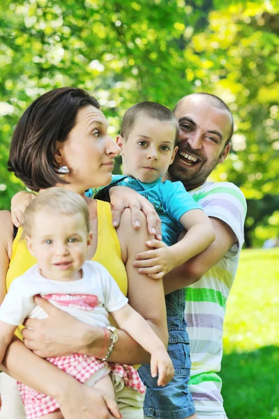 Happy young couple with their children have fun at park — Stock Photo, Image