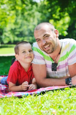 Happy father and son have fun at park clipart