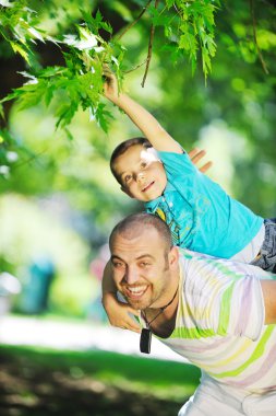 Happy father and son have fun at park clipart