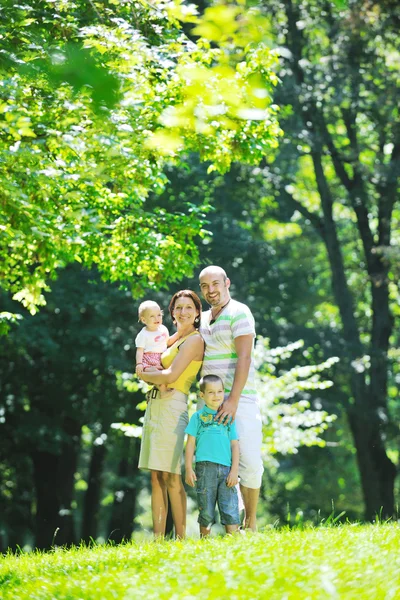 Happy young couple with their children have fun at park — Stock Photo, Image