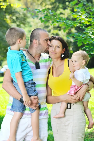 Felice giovane coppia con i loro figli divertirsi al parco — Foto Stock