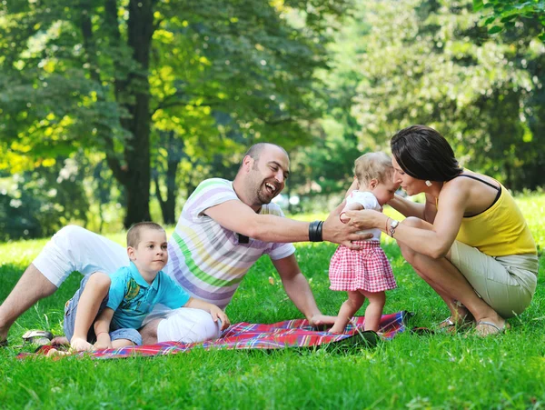 Feliz pareja joven con sus hijos divertirse en el parque — Foto de Stock