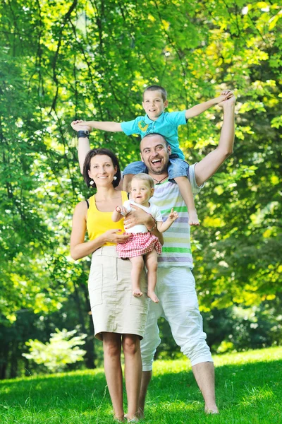 Heureux jeune couple avec leurs enfants s'amuser au parc — Photo