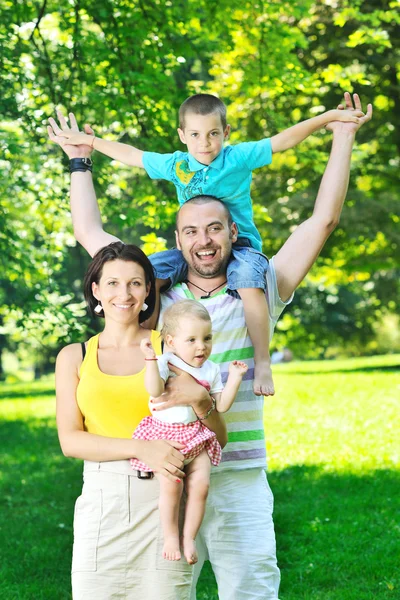 Boldog, fiatal pár azok children szórakozni a park — Stock Fotó