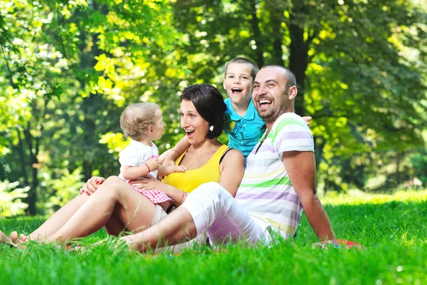 Feliz pareja joven con sus hijos divertirse en el parque —  Fotos de Stock