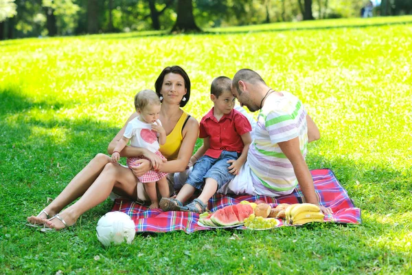 Šťastný mladý pár s dětmi bavit v parku — Stock fotografie