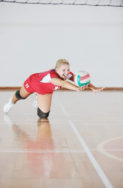 Девочка играет в волейбол в помещении — стоковое фото