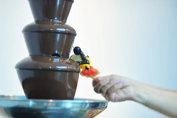 Flüssiger Schokoladenbrunnen und frisches Obst am Stock — Stockfoto