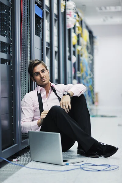 Empresario con portátil en la sala de servidores de red — Foto de Stock