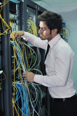 Young it engineer in datacenter server room clipart