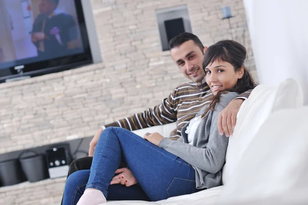 Χαλαρή νεαρό ζευγάρι βλέποντας τηλεόραση στο σπίτι — Φωτογραφία Αρχείου