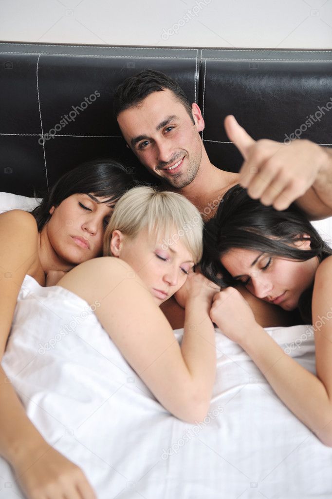 hombre guapo acostado en la cama con tres chicas: fotografía de stock © .shock #7556168 Depositphotos