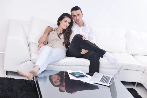 Neşeli çift rahatlayıp modern evdeki dizüstü bilgisayarda çalışıyor. — Stok fotoğraf