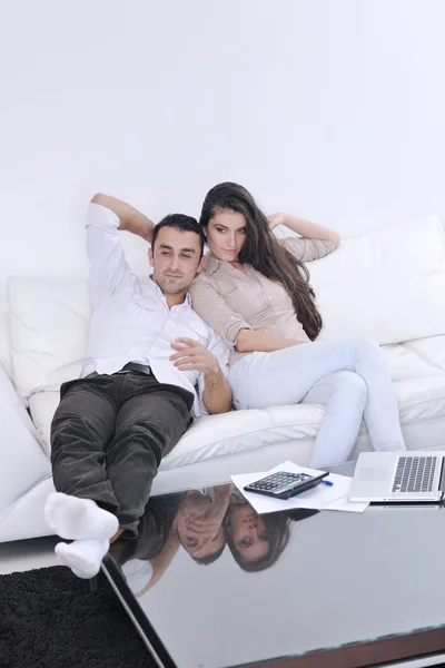 Радісна пара відпочиває і працює на ноутбуці в сучасному будинку — стокове фото