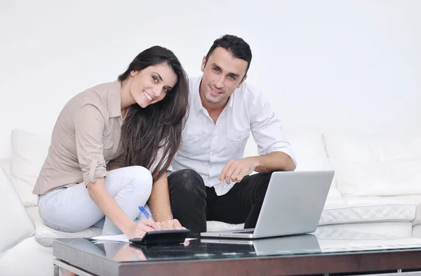 Glada par koppla av och arbeta på bärbar dator i moderna hem — Stockfoto