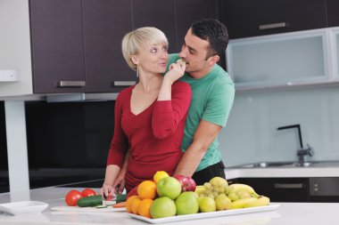 Genç çift modern mutfakta eğleniyor.