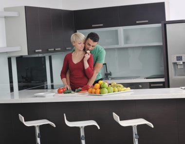 Genç çift modern mutfakta eğleniyor.