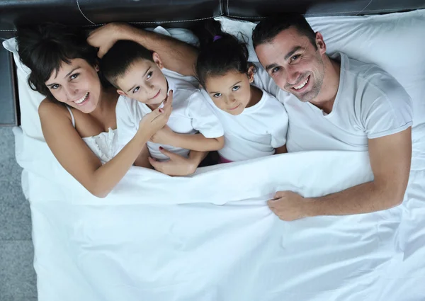 Щаслива молода сім'я у своїй спальні — стокове фото
