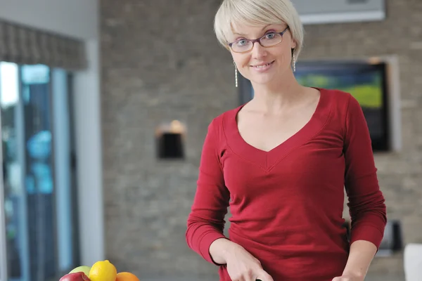 Glada vackra blonda kvinnan laga mat i köket — Stockfoto