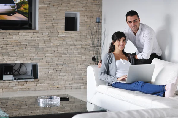 Joyful couple relax and work on laptop computer at modern home — Stock Photo, Image