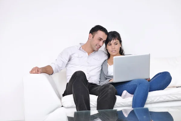Radostný pár relaxovat a pracovat na notebooku v moderním domě — Stock fotografie