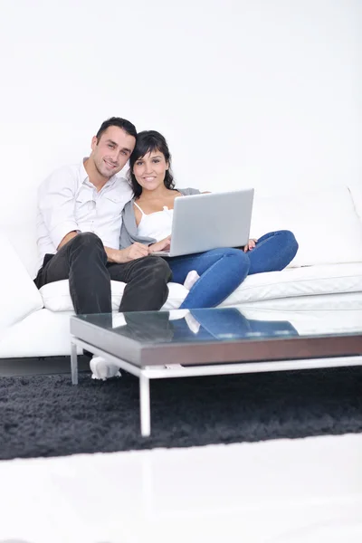 Coppia gioiosa rilassarsi e lavorare sul computer portatile a casa moderna — Foto Stock