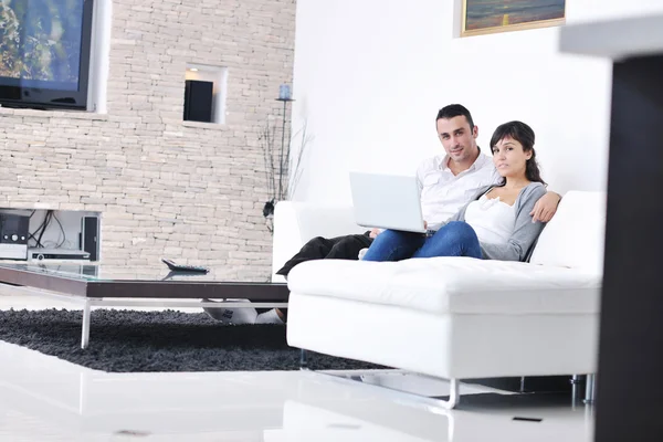 Couple joyeux se détendre et travailler sur ordinateur portable à la maison moderne — Photo