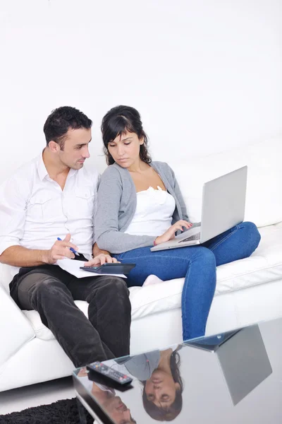 快乐的夫妻放松一下，在现代家里的笔记本电脑上工作 — 图库照片