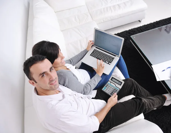 Coppia gioiosa rilassarsi e lavorare sul computer portatile a casa moderna — Foto Stock
