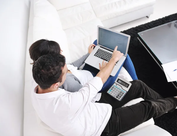 Glada par koppla av och arbeta på bärbar dator i moderna hem — Stockfoto