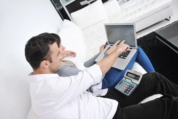 Pareja alegre relajarse y trabajar en el ordenador portátil en el hogar moderno — Foto de Stock