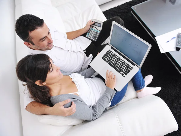 Fröhliches Paar entspannt sich und arbeitet zu Hause am Laptop — Stockfoto