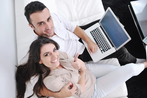 楽しいカップルは現代の家庭でノートパソコンをリラックスして仕事をし — ストック写真