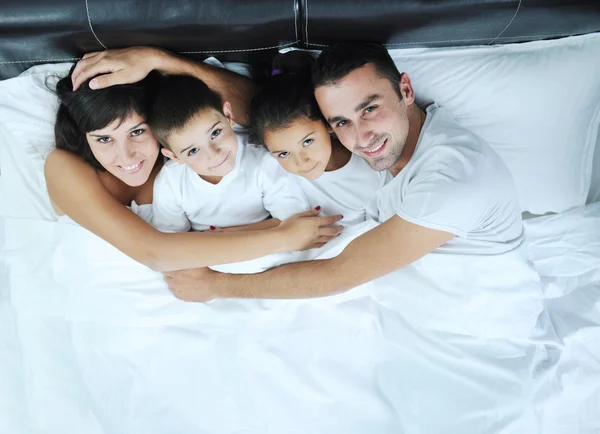 Familia joven feliz en su dormitorio —  Fotos de Stock