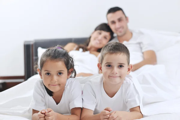 Familia joven feliz en su dormitorio — Foto de Stock