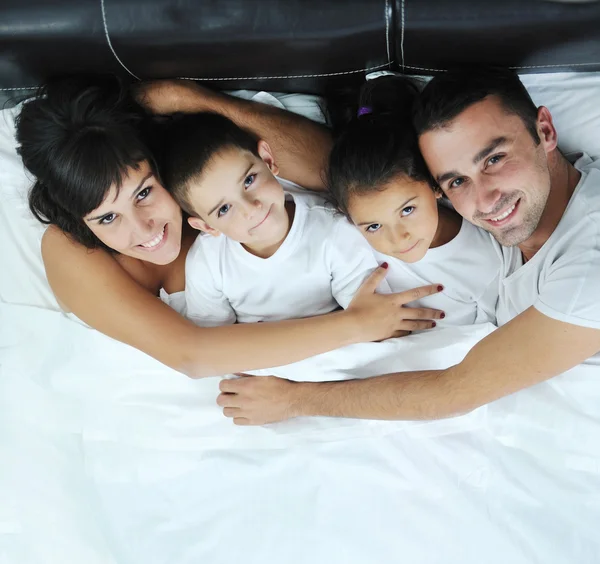 Glückliche junge Familie im Schlafzimmer — Stockfoto