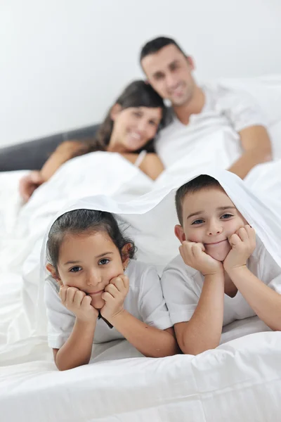 Familia joven feliz en su dormitorio — Foto de Stock