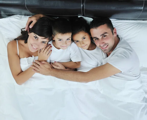 Glückliche junge Familie im Schlafzimmer — Stockfoto