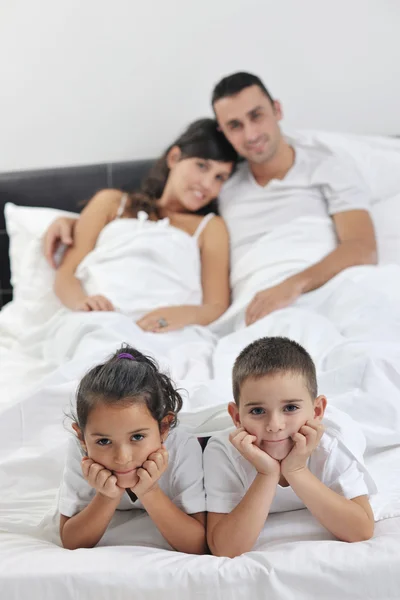 Щаслива молода сім'я у своїй спальні — стокове фото