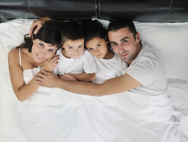 Gelukkige jonge familie in hun slaapkamer — Stockfoto