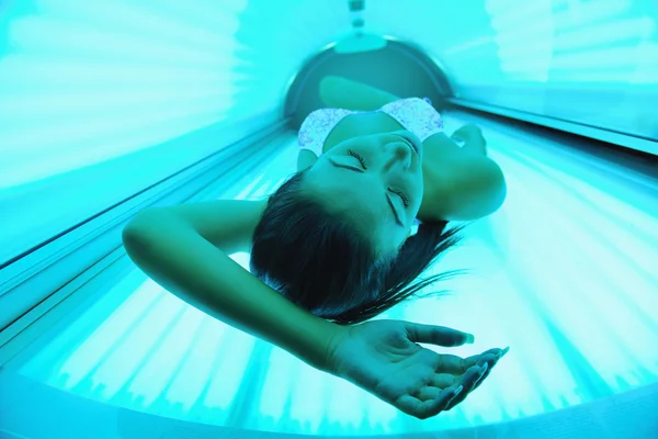 Beautiful young woman tanning in solarium — Stock Photo, Image