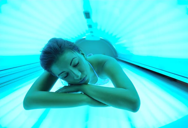 Beautiful young woman tanning in solarium — Stock Photo, Image