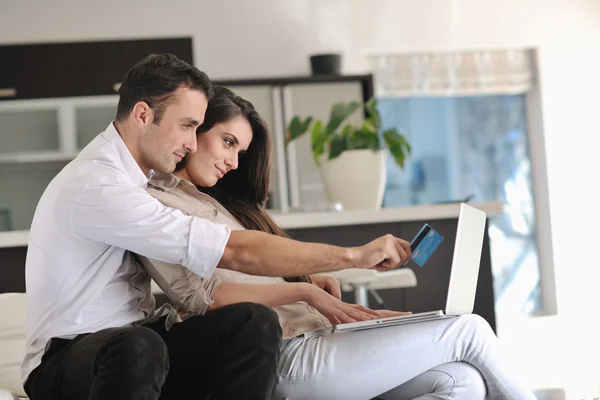 快乐的夫妻放松一下，在现代家里的笔记本电脑上工作 — 图库照片